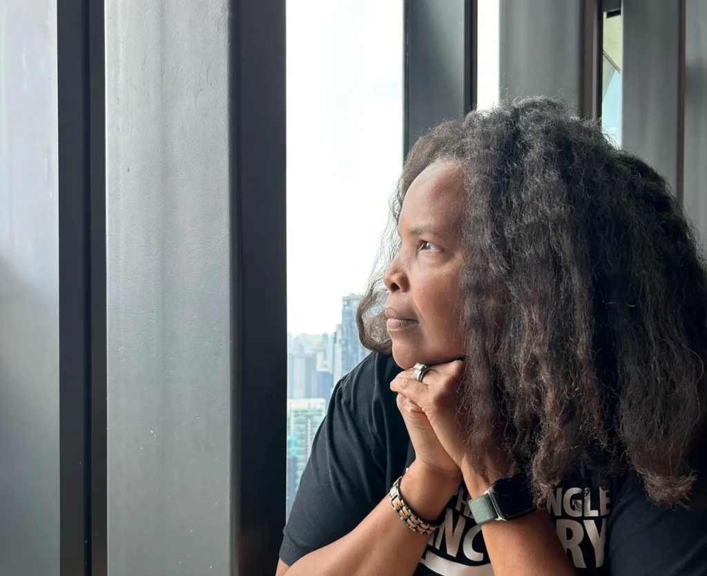 A woman with long hair is looking out of the window.