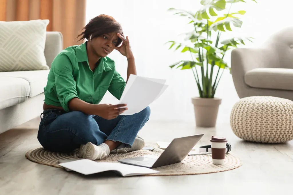 A woman sitting on the floor reading papers