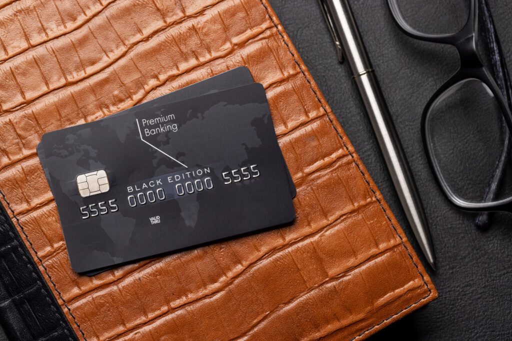 Black credit card on brown leather wallet.