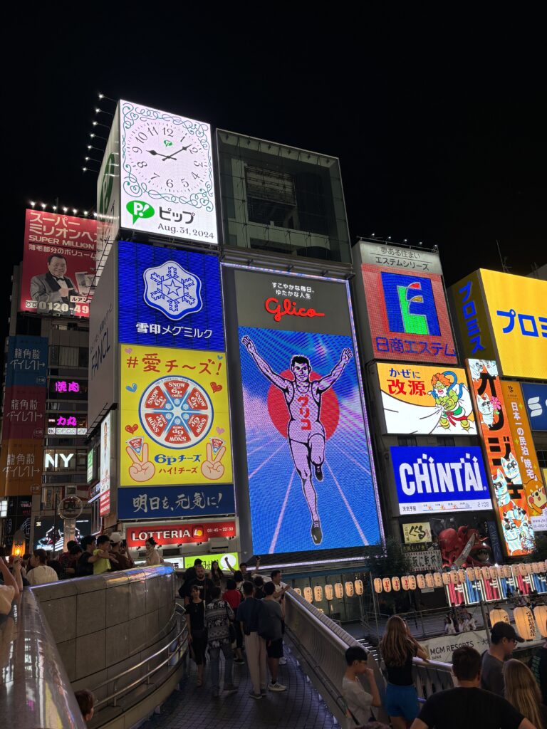 A large display of various advertisements on the side of a building.