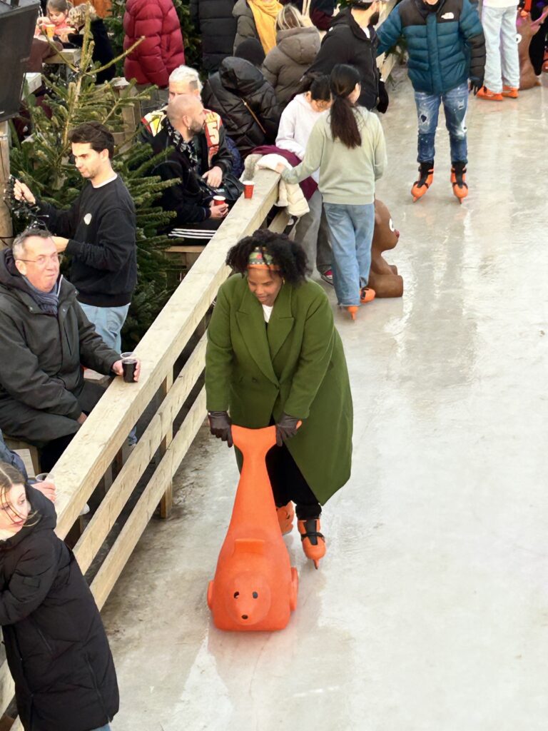 Woman with orange seal skating aid on ice