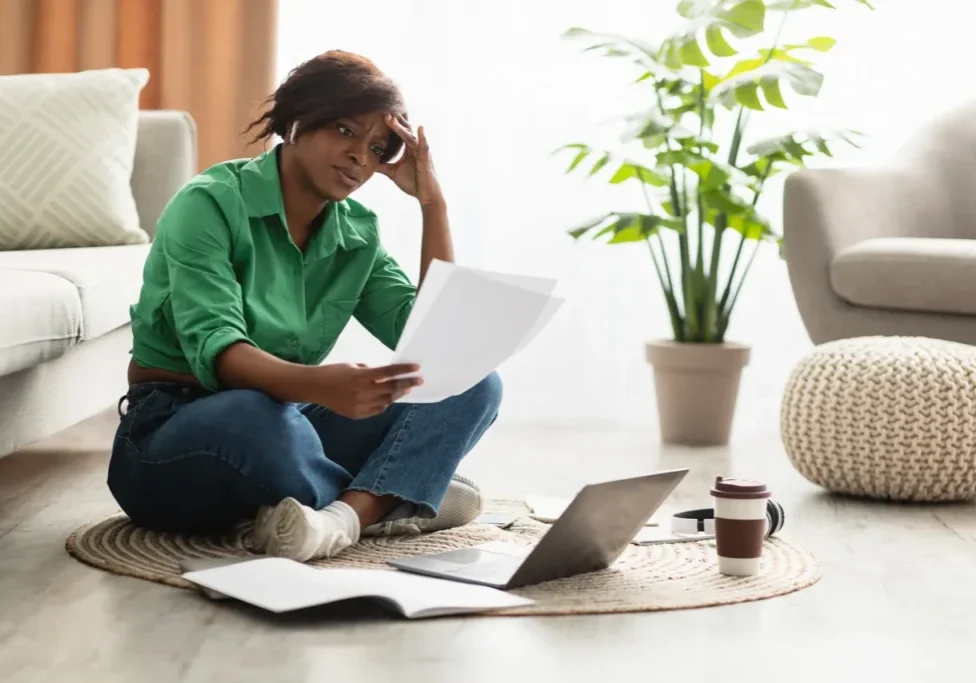 A woman sitting on the floor reading papers